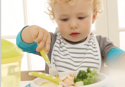 [Translate to Italian:] little kids learn to eat